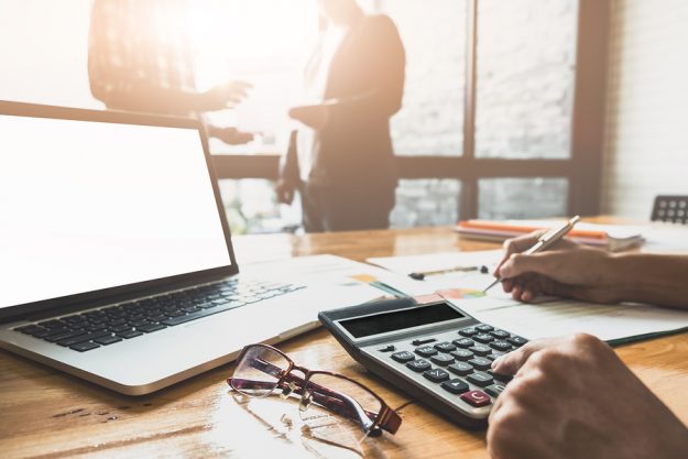 Close Up Businessman And Partner Using Calculator And Laptop For